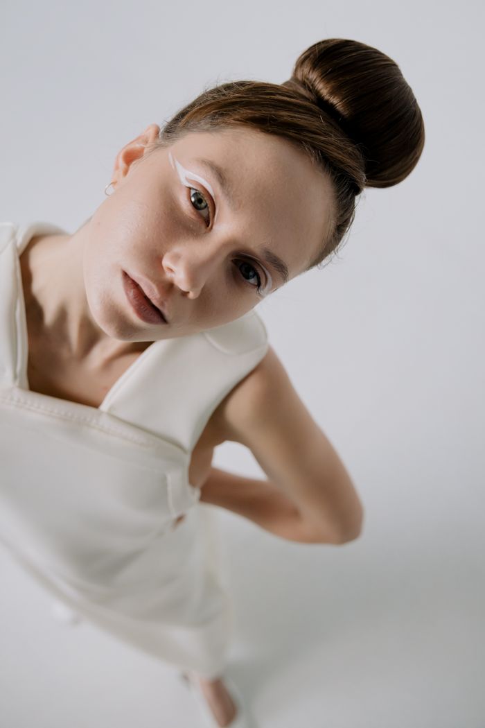 Elegant portrait of a woman with art makeup and white dress.